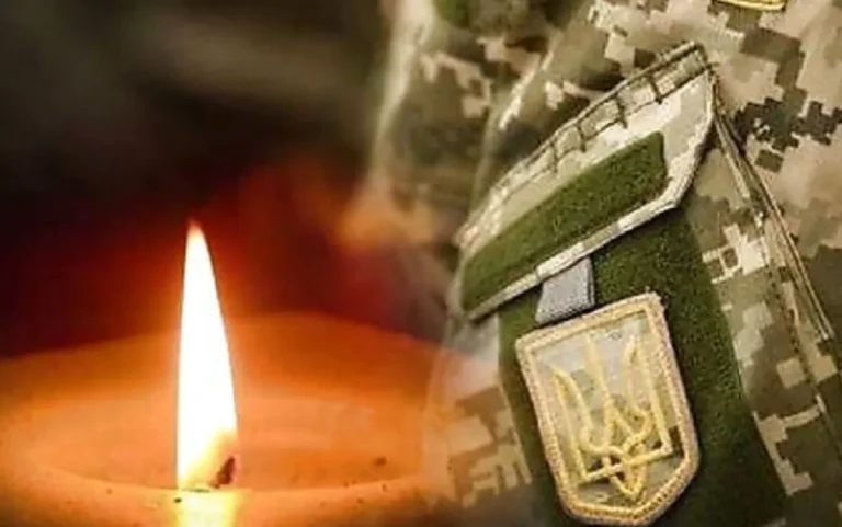 Запалена свічка біля рукава камуфляжної форми ЗСУ з нашивкою Тризуба
