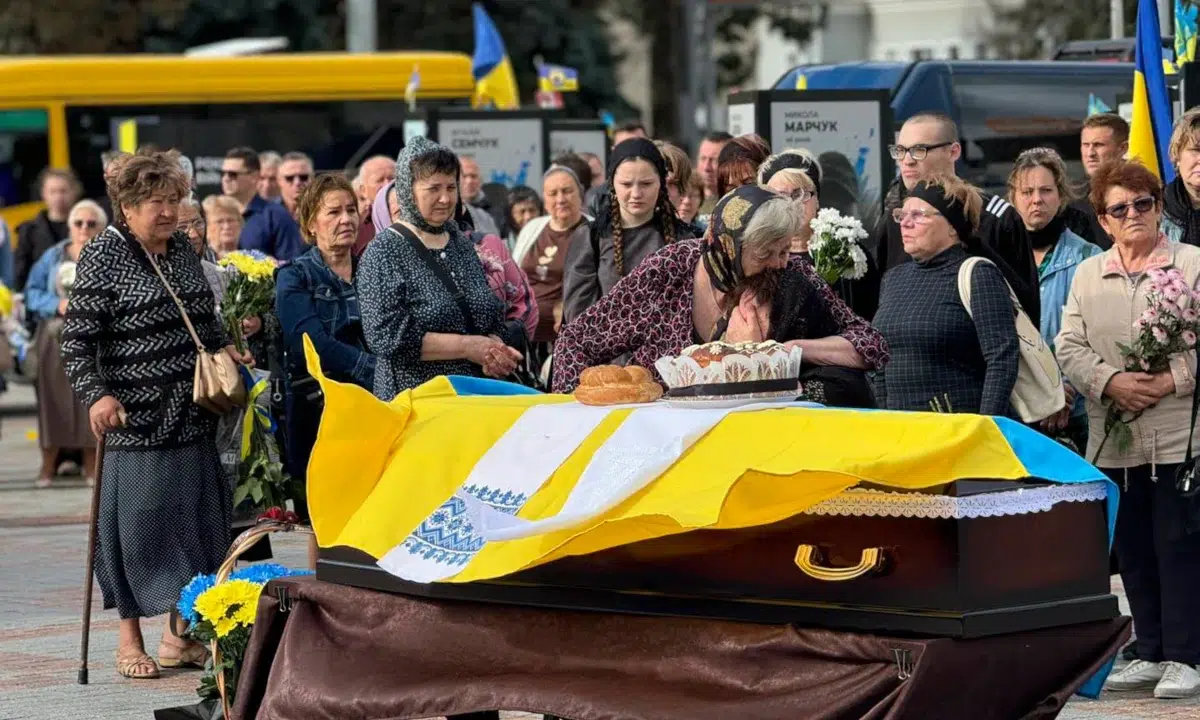 Прощання у Рівному: труна під прапором України, хліб, квіти й люди в жалобі